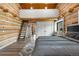 Cozy primary bedroom showcasing timber frame and ladder to loft and seating area at 1651 Pine Valley Rd, Evergreen, CO 80439