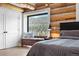 Charming primary bedroom with storage seating under the window and mountain view at 1651 Pine Valley Rd, Evergreen, CO 80439