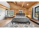 Cozy primary bedroom with exposed beams, an accent rug, and a comfortable seating area at 1651 Pine Valley Rd, Evergreen, CO 80439