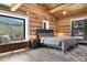Inviting primary bedroom featuring exposed beams, a bench seat, and mountain views at 1651 Pine Valley Rd, Evergreen, CO 80439