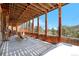 Covered porch with open framing, rocking chairs, stone accents, and scenic mountain views at 1651 Pine Valley Rd, Evergreen, CO 80439