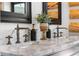 Close up of the vanity with marble countertop, dual sinks, stylish fixtures, and decorative accessories at 1651 Pine Valley Rd, Evergreen, CO 80439