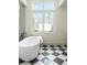 Bright bathroom features a freestanding tub, large window, and modern black and white tile flooring at 510 Glencoe St, Denver, CO 80220