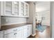 Butler's pantry with white cabinetry, and granite countertop, providing ample storage and preparation space at 11584 Pine Canyon Ln, Parker, CO 80138