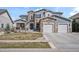Charming two-story home with a stone and siding exterior, three-car garage, and well-maintained front lawn at 11584 Pine Canyon Ln, Parker, CO 80138