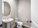 Stylish half bathroom with a pedestal sink, decorative mirror, and modern fixtures at 11584 Pine Canyon Ln, Parker, CO 80138