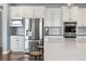 Close-up of a modern kitchen with stainless steel appliances and a large white countertop island with barstools at 11584 Pine Canyon Ln, Parker, CO 80138