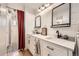 Modern bathroom with double vanity, sleek fixtures, wood floor, and a shower behind a red curtain at 865 S 8Th Ave, Brighton, CO 80601