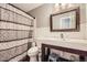 Bathroom featuring a decorative shower curtain, framed mirror, sink, and toilet at 865 S 8Th Ave, Brighton, CO 80601