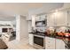Bright kitchen with stainless steel appliances, black countertops, white cabinets, and decorative backsplash at 865 S 8Th Ave, Brighton, CO 80601