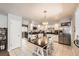 Well-lit kitchen features stainless steel appliances, tiled floor, and attached dining area with table at 865 S 8Th Ave, Brighton, CO 80601
