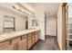 Double vanity bathroom with wood cabinets and a shower at 7851 S Quatar Ct, Aurora, CO 80016