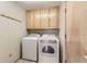 Clean laundry room with washer, dryer, and wood cabinets at 7851 S Quatar Ct, Aurora, CO 80016