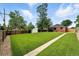Spacious backyard with lush green lawn, bordered by a wooden fence and mature trees for privacy at 2955 Poplar St, Denver, CO 80207