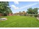 Expansive backyard featuring a well-maintained lawn, a wood fence, and mature trees providing shade and privacy at 2955 Poplar St, Denver, CO 80207