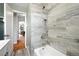 Updated bathroom with marble-look tile, soaking tub, and modern fixtures at 2955 Poplar St, Denver, CO 80207
