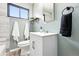 Bright bathroom with a modern vanity, light green walls and decorative fixtures at 2955 Poplar St, Denver, CO 80207