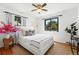 Cozy bedroom with a ceiling fan, hardwood floors, and natural light from a large window at 2955 Poplar St, Denver, CO 80207