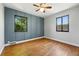 Sunlit bedroom featuring hardwood floors, paneled accent wall and generous windows with natural light at 2955 Poplar St, Denver, CO 80207