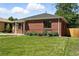 Side view of a brick home featuring a green lawn, and a clean exterior with dark trim at 2955 Poplar St, Denver, CO 80207