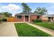 Attractive brick house with a green lawn, a paved driveway, and lovely curb appeal at 2955 Poplar St, Denver, CO 80207
