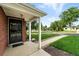 Welcoming front porch with brick columns, a security door, and a view of the landscaped lawn at 2955 Poplar St, Denver, CO 80207