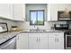 Bright kitchen featuring stainless appliances, granite counters, white subway tile and modern white cabinetry at 2955 Poplar St, Denver, CO 80207