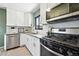 Well-lit kitchen featuring stainless steel appliances, granite countertops, and white cabinetry at 2955 Poplar St, Denver, CO 80207