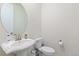 Charming powder room features a pedestal sink and round mirror at 8234 S Vandriver Way, Aurora, CO 80016
