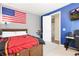 Stylish bedroom with a wood-paneled bedframe, mounted TV, and American flag evokes a youthful vibe at 8234 S Vandriver Way, Aurora, CO 80016