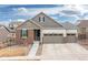 Charming single-Gathering home featuring a three-car garage and an inviting entrance with stone accents at 8234 S Vandriver Way, Aurora, CO 80016