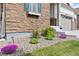 Beautifully landscaped front yard with stone accents and colorful flowering plants at 8234 S Vandriver Way, Aurora, CO 80016
