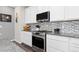 Modern kitchen with stainless steel appliances, white cabinetry, and granite countertops at 8234 S Vandriver Way, Aurora, CO 80016