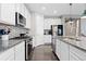 Spacious kitchen with a central island, white cabinets, and modern stainless steel appliances at 8234 S Vandriver Way, Aurora, CO 80016