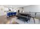 Open-concept with a blue kitchen island and a dark wood dining table with a modern bench and chairs at 8234 S Vandriver Way, Aurora, CO 80016