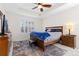 Primary bedroom with tray ceiling, shuttered windows, wood furniture, and a cozy rug at 8234 S Vandriver Way, Aurora, CO 80016
