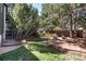 A fire pit area is nestled within the backyard amongst mature trees, alongside a grassy lawn area at 10028 Chelmsford Ter, Parker, CO 80134