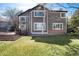 Back exterior view of home with a wood deck, large windows and lush green lawn at 10028 Chelmsford Ter, Parker, CO 80134