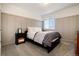Comfortable bedroom featuring a black bed frame, stylish paneled wall, and soft natural light at 10028 Chelmsford Ter, Parker, CO 80134
