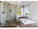 Modern main bathroom features a soaking tub, glass shower, stone tiles, and white shiplap walls at 10028 Chelmsford Ter, Parker, CO 80134