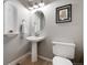 Charming powder room featuring pedestal sink, decorative niche, neutral paint, and tiled floors at 10028 Chelmsford Ter, Parker, CO 80134