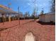 Spacious backyard featuring a wooden fence, red mulch, and covered seating area at 992 Toledo St, Aurora, CO 80011