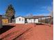 Exterior shot of the home's backyard with a covered patio and a white exterior at 992 Toledo St, Aurora, CO 80011