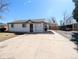 Charming home featuring a well-maintained lawn, a driveway, and a covered carport at 992 Toledo St, Aurora, CO 80011