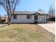 Charming home featuring a well-maintained lawn, a driveway, and a covered carport at 992 Toledo St, Aurora, CO 80011