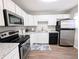 Bright kitchen features stainless steel appliances, white cabinets, and granite countertops at 992 Toledo St, Aurora, CO 80011