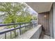 Balcony view showing the railing, brick exterior, and street with trees below at 830 N Sherman St # 208, Denver, CO 80203