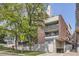 Brick apartment building with a street side view, trees, and visible signage at 830 N Sherman St # 208, Denver, CO 80203