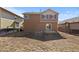 Backyard with dormant grass and the home's exterior, plus an adjacent house at 16643 E 101St Ave, Commerce City, CO 80022