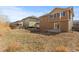 View of a backyard featuring dormant grass and neighboring houses at 16643 E 101St Ave, Commerce City, CO 80022